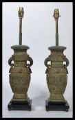 A pair of Chinese bronze table lamps of baluster form, geometric chased design raised on stepped