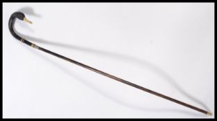 A vintage 20th century walking stick cane having a tapering wooden shaft with brass and silver white