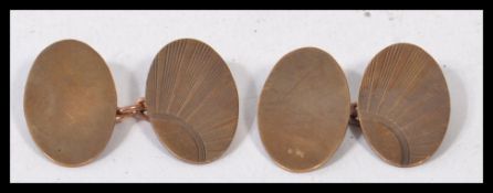 A pair of early 20th century hallmarked 9ct gold art deco rising sun sunburst cuff links of oval
