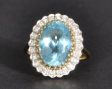 A 9ct gold blue stone and diamond ring having a large central faceted blue stone with a halo of