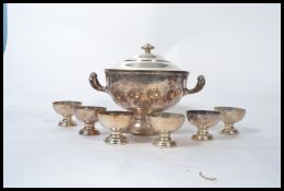 A large silver plated punch tureen with lid along with six Mappin and Webb punch bowls. The tureen