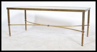 A 20th century brass and smoked glass coffee table, brass base raised on column legs united by