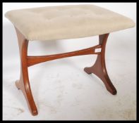 A retro 1970's retro G-Plan teak wood dressing table stool being raised on angular supports united