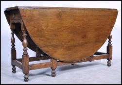 An 18th century Welsh country oak drop leaf dining table of large form being raised on block and