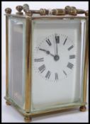 An early 20th century brass carriage clock with enamel dial, roman numeral chapter ring with faceted