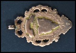 A vintage 20th century hallmarked 9ct gold Armorial shield fob medal. Weight 6.4g. Measures 3.5 cm
