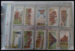 An album of vintage cigarette cards including Players Army Life , Wills military motors and many