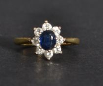 An 18ct gold diamond and sapphire ring having a central sapphire with a halo of diamonds. Size J