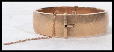 A hallmarked 9ct gold bangle bracelet having hidden clasp. Hallmarked for Birmingham 1995 makers S&
