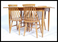 A 1970's retro teak wood extending dining table being raised on turned legs with fitted frieze