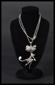 A sterling silver necklace chain and pendant in the form of an art deco cat with pearl panel to tail
