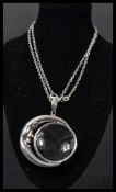 A sterling silver magnifying glass on necklace chain. The pendant of half moon shape.