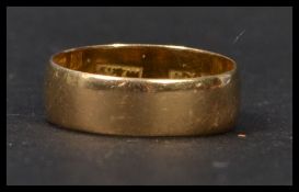 An 18ct gold wedding band ring of typical form being stamped 18ct. Size M weighs 3.6 grams.