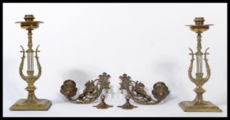 A pair of late 19th century Victorian brass candlesticks of Lyre shape raised on pedestal bases
