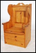 A small 20th century child's pine settle with high back and sides panel seat with storage to the