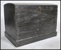 A vintage 20th century dome top ebonised trunk. Constructed from elm panels with hinged dome top