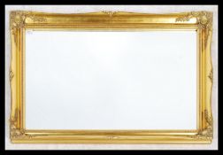 A large 20th century gilt wood mirror having decorative gilt frame having central bevelled mirror