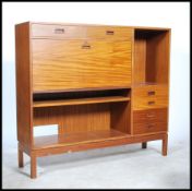 A 1970's teak wood Danish influence high board sideboard raised on squared legs with a bank of