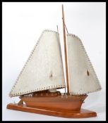 A vintage mid 20th century teak wood table / bedside lamp in the form of a boat having two shades