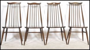 A set of four 20th century vintage Ercol beech and elm stick back dining chairs