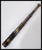 An ebonised three draw brass telescope with applied plaque reading W. Ottaway & Co Ltd Ealing London