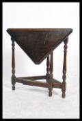 A vintage 20th century oak Jacobean revival occasional table having a single leaf to front raised on