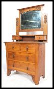 An Edwardian Arts & Crafts oak dressing table chest of drawers having a swing mirror over an