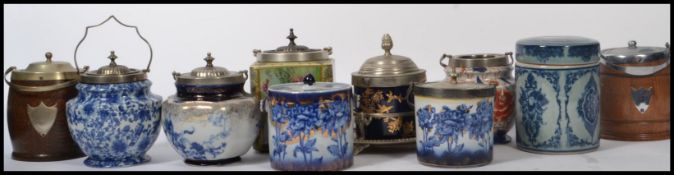 A collection of biscuit barrels dating from the early 20th century to include both ceramic and oak