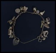A hallmarked 9ct gold heart padlock charm bracelet having various gold charms including a ruby and
