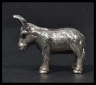 A sterling silver miniature figurine of a donkey having inset ruby eyes. Weighs 20 grams.