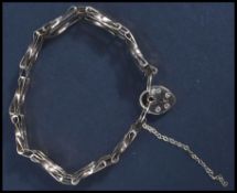 A 9ct gold hallmarked bracelet with a heart shaped locket set to a figaro chain. Weighing 6.4g.