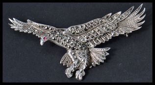 A silver and marcasite brooch in the form of an eagle with red stone eye and safety clasp stamped