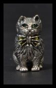 A sterling silver miniature figurine of a cat having emerald inset eyes. Weighs 17 grams.