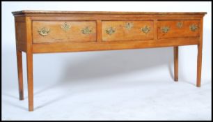 An 18th century elm topped dresser base - sideboard. Raised on square tapering legs with a series of