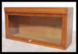 A vintage early 20th century lawyers bookcase cabinet with hinged fold over glass door by D Matthews