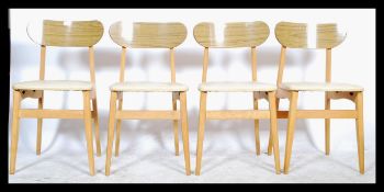 A set of 4 mid century retro dining chairs having faux teak wood propeller style back rests with
