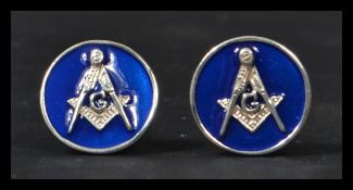 A pair of sterling silver cuff-links having blue enamel backs with masonic interest symbols.