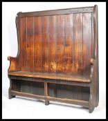 A large Victorian pine hall settle having a planked seat raised over pierced apron the underside.