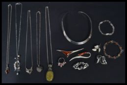 A collection of sterling silver and silver jewellery to include rings , brooches , amber ,