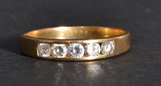 A 14k gold diamond band ring having four inset diamonds. Size R weighs 2.9 grams.