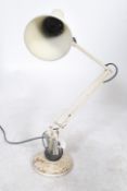 A vintage 20th century Herbert Terry anglepoise desk lamp being raised on circular base with a