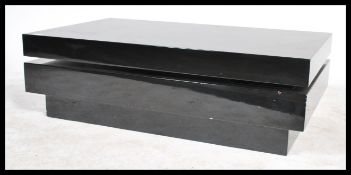 A 20th century contemporary lacquered block coffee table in a black finish having a swivel top