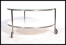 A good 20th century chrome and glass circular coffee table raised on castors having twin white glass