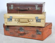 A collection of vintage retro suitcases to include leather examples, some with remnants of