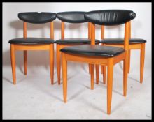 A set of 4 mid century retro Danish influence dining chairs of teak construction having black faux