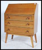 A retro 20th century teak wood bureau with a fully appointed top with fall front over three