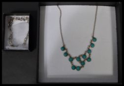 A sterling silver demi parure necklace and earring set having turquoise stones.