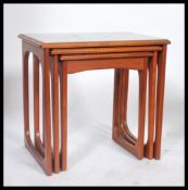 A nest of three teak wood occasional tables in the manner of G Plan's Quadrille pattern, each