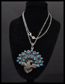 A sterling silver pendant in the form of a pendant with marcasite and opals with garnet stone eye.