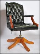 A 20th century green leather Chesterfield style deep button back swivel mahogany framed captains